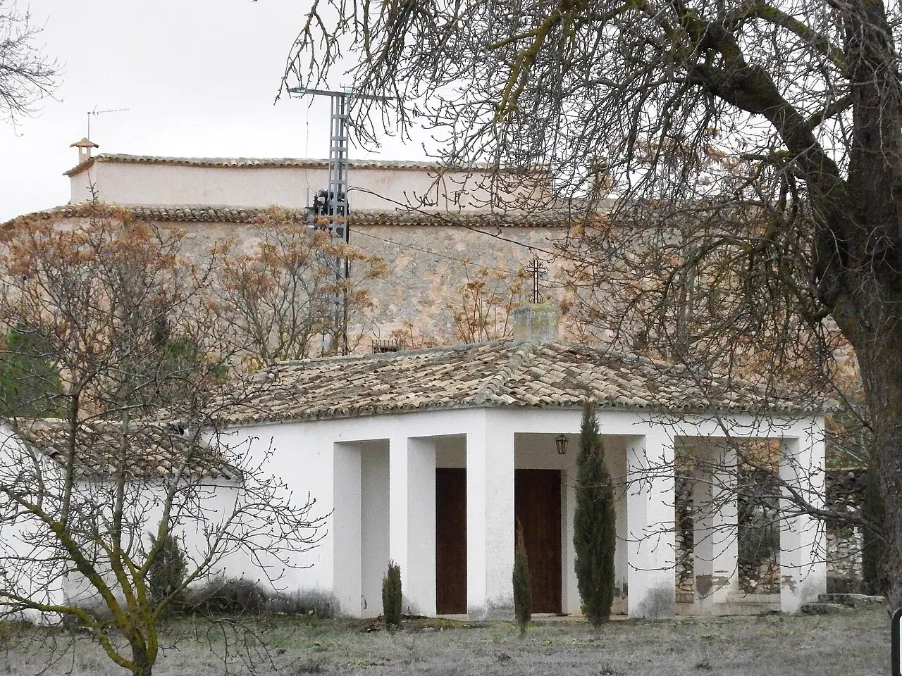 Fachada porticada de Torrebuceit delante de un muro de mampostería